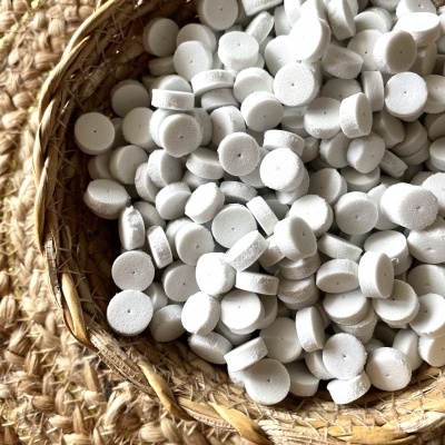 Cesto rústico com pastilhas brancas circulares sobre superfície trançada