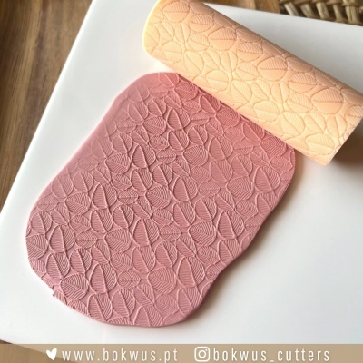 Rolo de textura para pasta de açúcar com padrão de folhas e pasta rosa texturizada