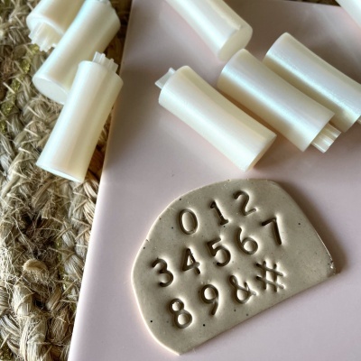 Cilindros brancos e placa cinzenta com números e símbolos embutidos