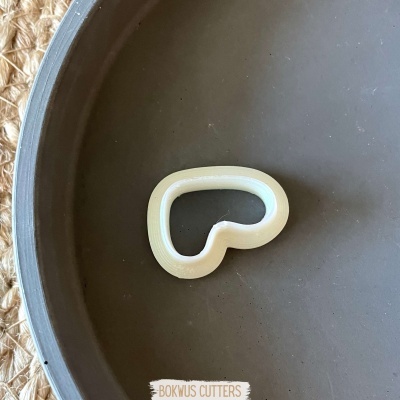 Cortador de biscoitos em forma de coração sobre prato cinzento