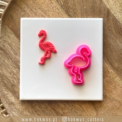 Molde de biscoito e corte em forma de flamingo cor-de-rosa sobre placa branca
