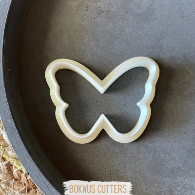 Cortante de borboleta branco sobre prato escuro com etiqueta BOKWUS CUTTERS