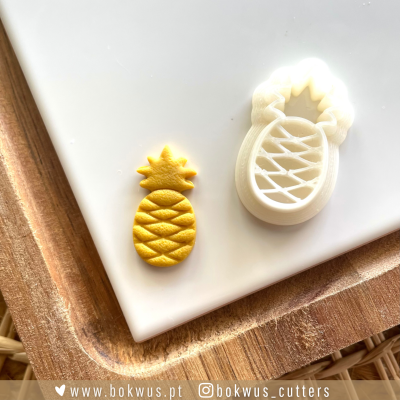 Cortador de biscoitos branco com formato de abacaxi e recorte amarelo em forma de abacaxi