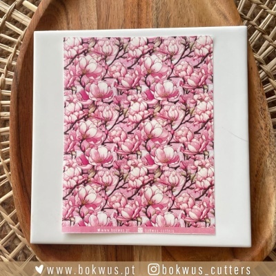 Papel decorativo floral rosa e branco sobre placa branca e bandeja de madeira