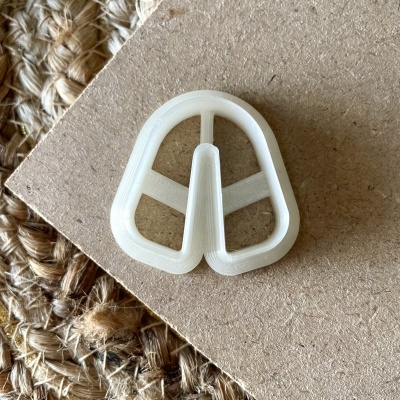 Objeto plástico branco triangular sobre madeira e tapete fibras