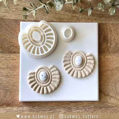 Moldes de corte em plástico branco e peças de massa moldadas em superfície branca sobre base de madeira