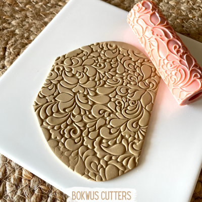 rolo de padrão em relevo sobre massa castanha em prato branco