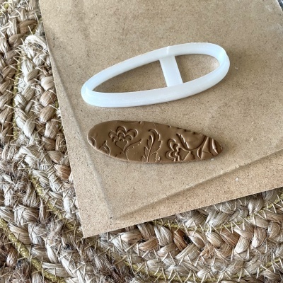 Acessórios para cabelo branco e castanho sobre cartão castanho em superfície de fibras trançadas