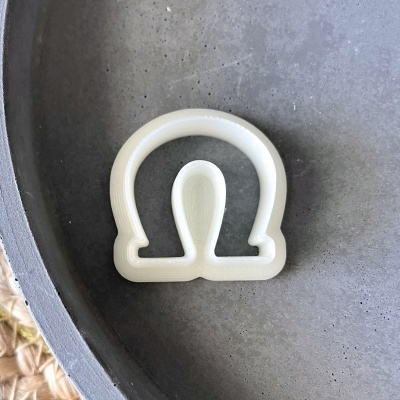 Forma de corte branca em plástico em prato cinzento fosco