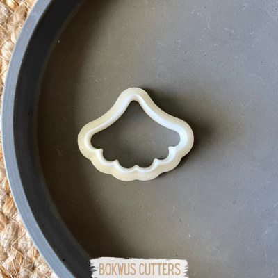 Forma para cortar biscoitos branco em prato cinzento sobre toalha de fibra natural