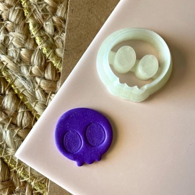 moldes de caveira branco e roxo sobre superfícies rosa clara e textura trançada