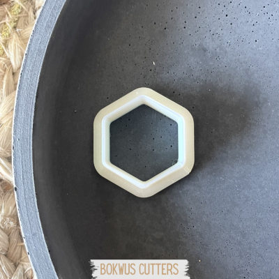 Cortador de biscoitos hexagonal branco numa tigela cinzenta