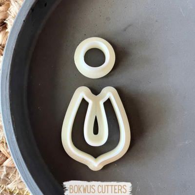 Cortantes de massa de plástico branco em forma de tulipa em prato cinza escuro