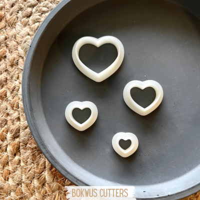 Conjunto de quatro cortadores de massa em forma de coração brancos
