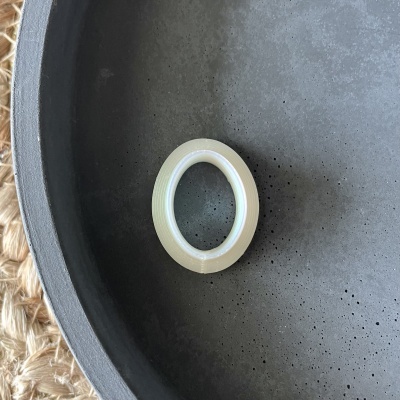 Rolo de fita adesiva transparente num prato cinzento com textura irregular