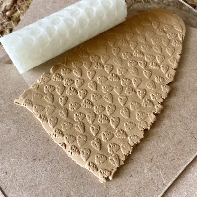 massa bege texturizada com padrão de corações e rolo branco gravado