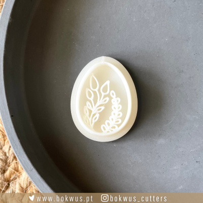 Forma de silicone oval com padrão de folhas em relevo, sobre superfície cinza