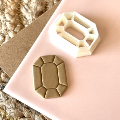 Cortador de massa e peça moldada octogonal sobre fundo cor-de-rosa e tapete natural