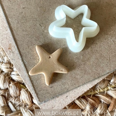 Cortador de biscoitos e estrela modelada sobre madeira e algodão trançado