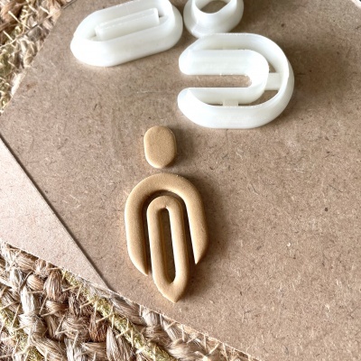 Figuras humanas estilizadas em plástico branco e bege sobre madeira clara e tapete rústico