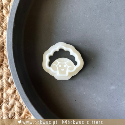 Cortador de biscoitos em forma de ovelha em fundo cinzento e tecido bege