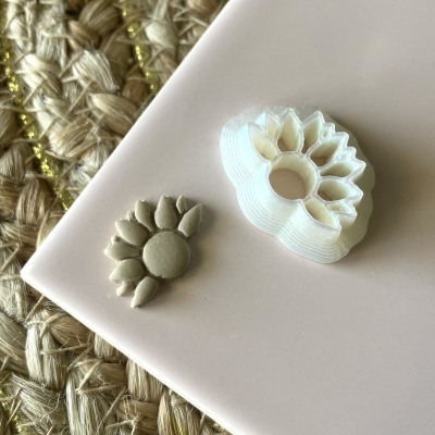 Carimbo de flor branco com impressão castanha sobre placa rosa