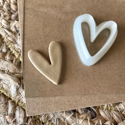 Dois corações, um castanho e outro branco translúcido, sobre cartão e fibras naturais