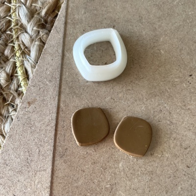 Três anéis quadrados arredondados, um branco translúcido e dois castanhos em cartão castanho