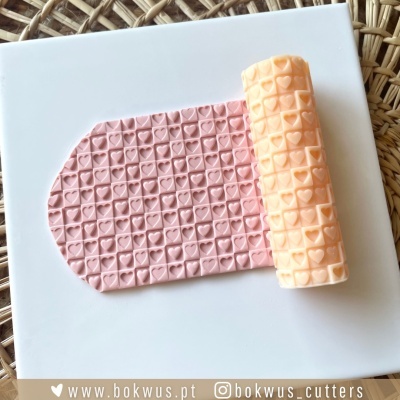 Rolo amarelo com padrão de corações aplicado em massa rosa sobre base branca