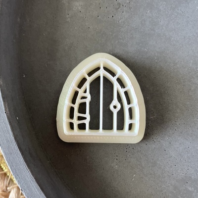 Cortador de massa branco em forma de porta arqueada com detalhes internos