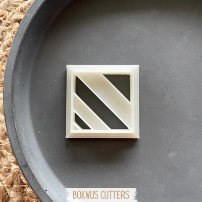 Cortador de massa quadrado branco com design de linhas diagonais na superfície preta