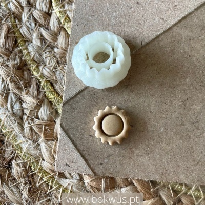 Dois pequenos objectos circulares ondulados branco e castanho sobre cartão e tapete tecido natural