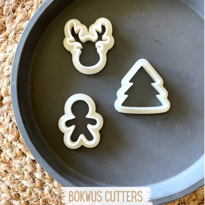 Moldes de cortadores para bolachas em formas natalícias sobre travessa cinzenta