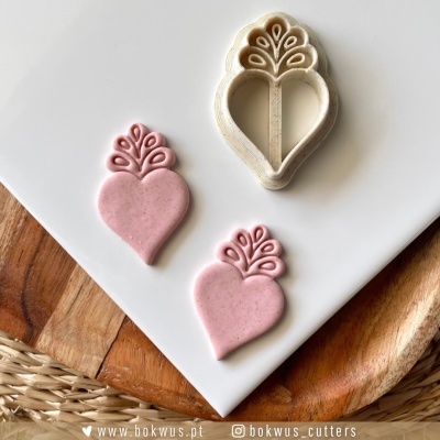 Cortantes de bolacha e bolachas cor-de-rosa em forma de coração com padrões