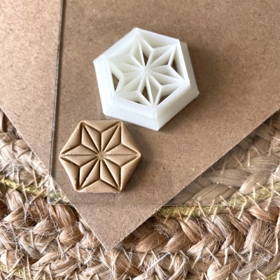 Objetos hexagonais decorativos branco e em madeira sobre superfície clara