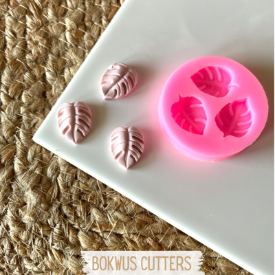 Molde silicone rosa para formas em forma de folhas com formas rosa claro em prato branco