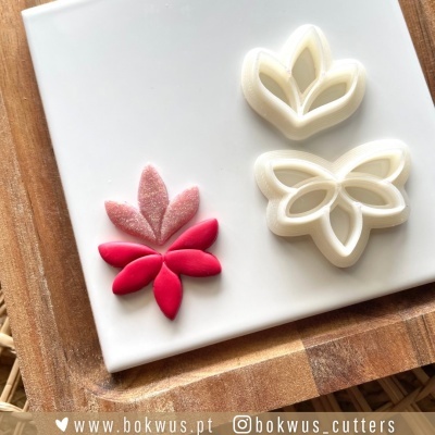 Cortadores brancos em forma de folhas com decoração de folhas vermelhas e rosa em pasta de açúcar