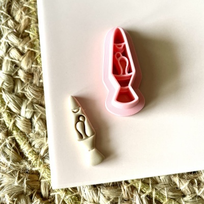 Carimbo de silicone rosa com peça branca sobre superfície branca e tapete de fibras naturais