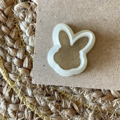 Cortador de biscoitos em forma de coelho sobre cartão e tapete trançado