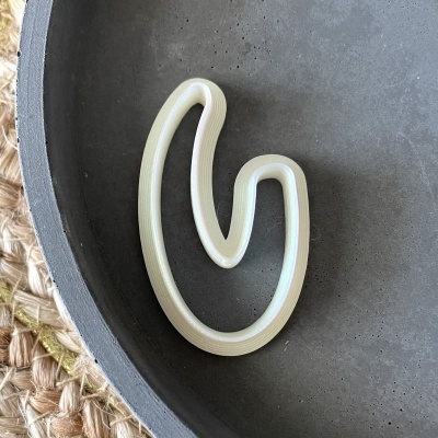 Clip creme canelado num prato cinza fosco sobre superfície trançada