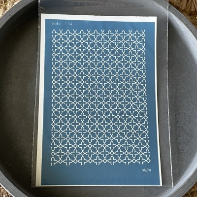 Cartaz com padrão de formas brancas em fundo azul sobre um prato cinzento.