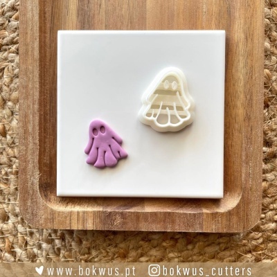 Carimbo e massa em forma de fantasma sobre placa branca e base de madeira