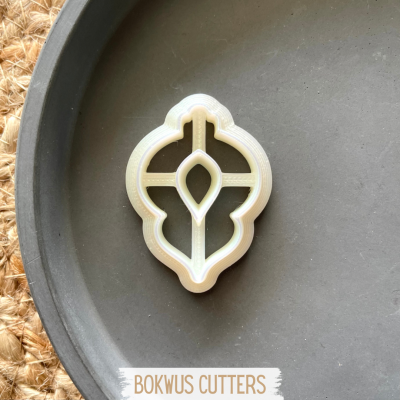 Cortador de bolachas branco com forma decorativa em travessa preta