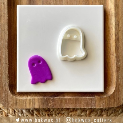 Cortador de bolachas formato fantasma branco com figura moldada roxa sobre placa branca e bandeja de madeira