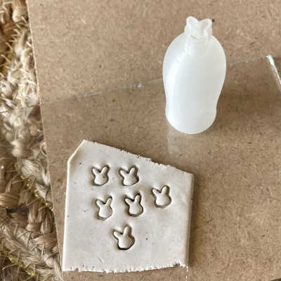 Carimbo de plástico branco em forma de cabeça de coelho com impressões em massa branca