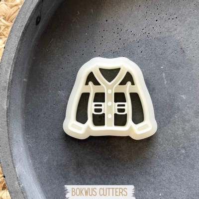 Cortador de biscoitos em forma de colete salva-vidas branco sobre superfície preta