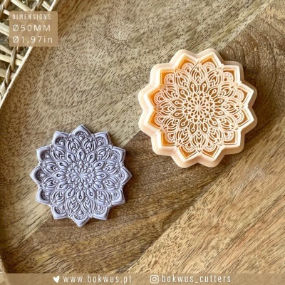 Dois cortadores de massa decorativos em forma de flor com padrões intrincados, em madeira.