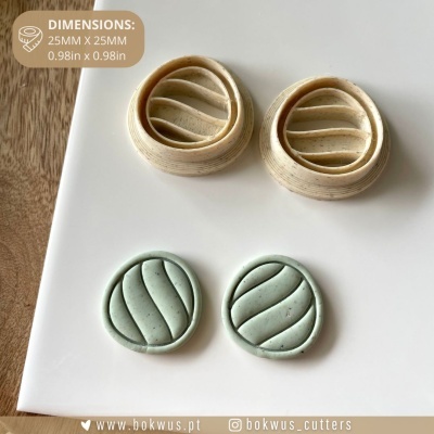 Cortadores redondos para massa em bege e verde com padrões ondulados em superfície branca