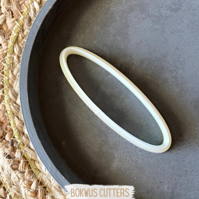 Pulseira branca fina em prato preto fosco sobre tecido trançado