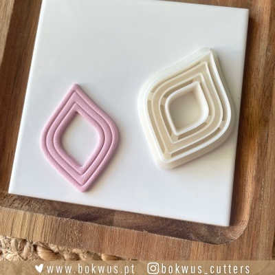 Cortadores de massa em forma de folha em branco e rosa sobre base branca